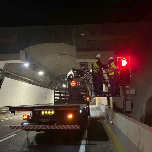 Faena nocturna en un túnel con señalización de seguridad y personal en altura